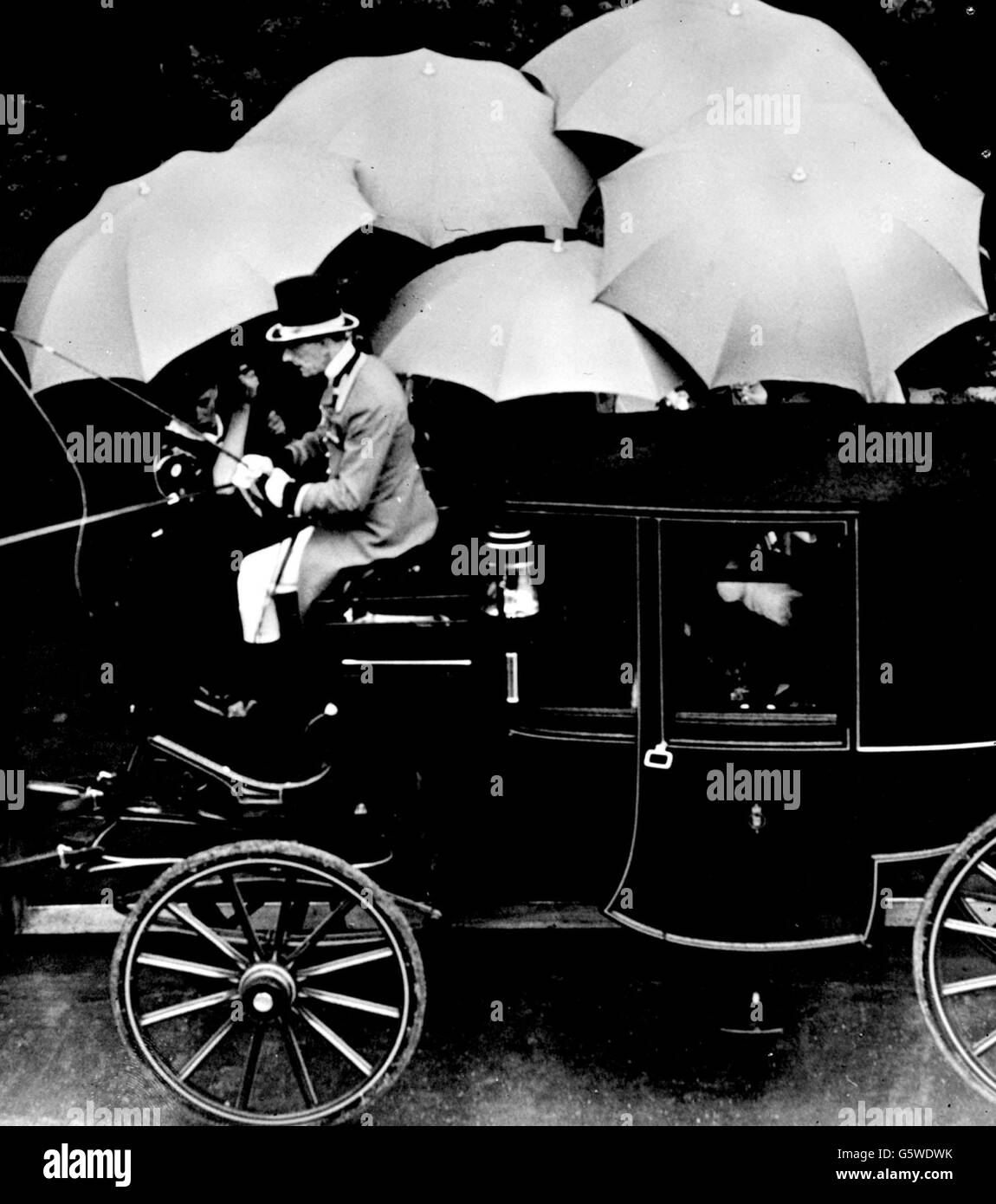 Des parasols sont tenus en altitude au-dessus de Sir Winston Churchill pour le protéger de la pluie lorsqu'il entre dans son autocar pour le voyage depuis l'abbaye après le couronnement de la reine. Banque D'Images
