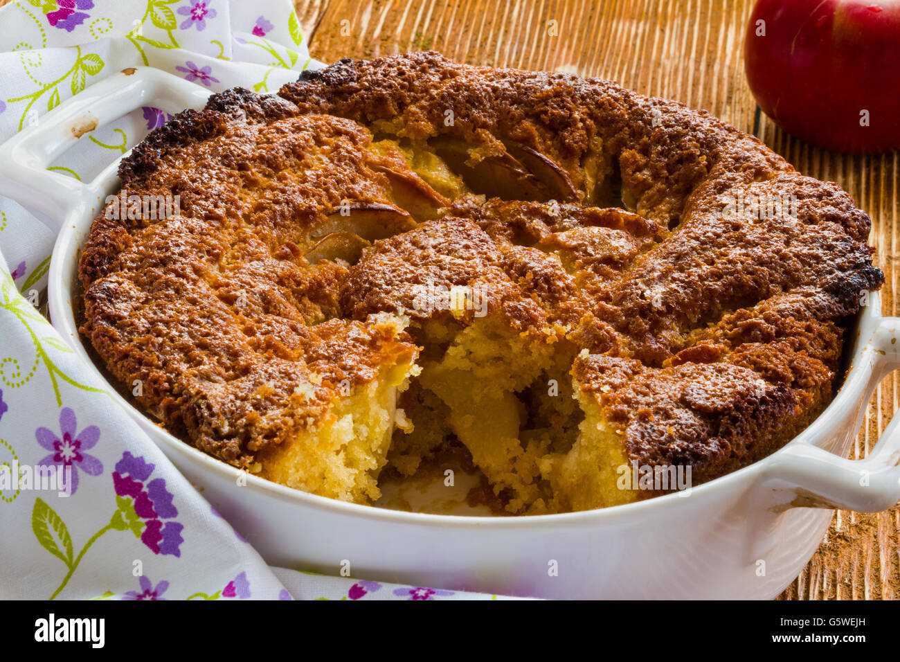 Tarte aux pommes dans un plat de cuisson blanc sur le fond de bois. Banque D'Images
