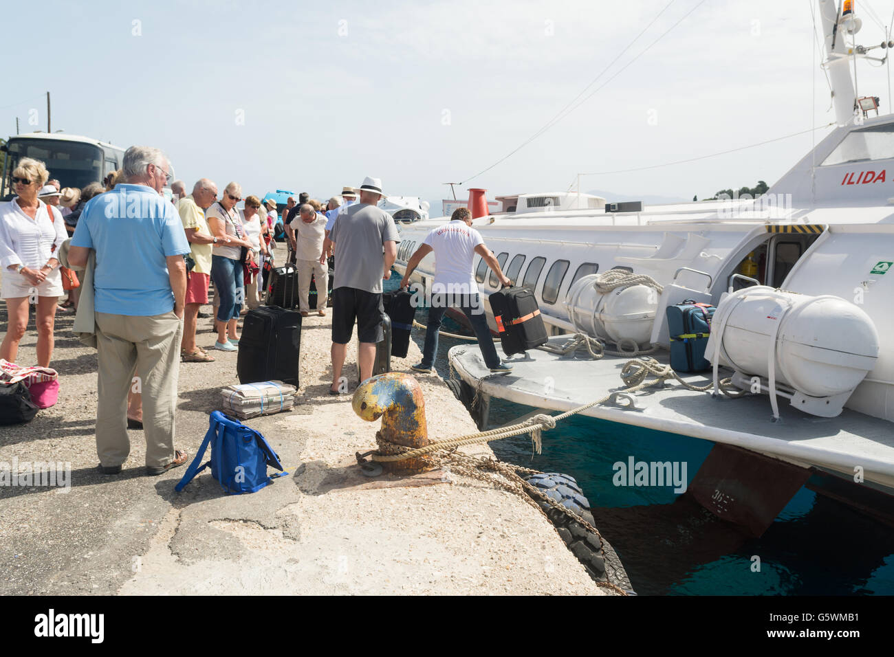 Membre de l'équipe d'aider les vacanciers avec leurs bagages avant qu'ils bord de l'hydroglisseur ILIDIA à Paxos pour revenir à Corfou, Grèce Banque D'Images