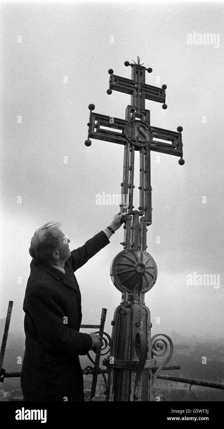 Le duc de Norfolk, président de l'appel de la cathédrale de Westminster, examinant la croix restaurée de 11 pieds de haut au sommet de la tour de la cathédrale, à 280 pieds au-dessus du sol, lorsqu'il a inspecté le premier travail de réparation. Banque D'Images