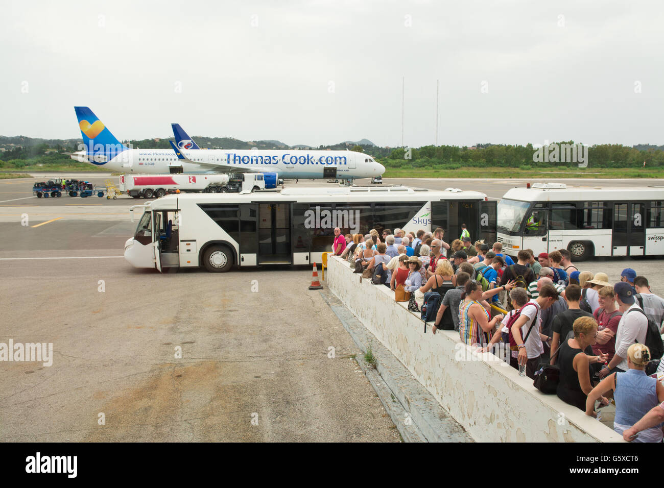 La queue pour les vacanciers de bus conseil transfert à Thomas Cook avion à l'aéroport de Corfou, Grèce, Europe Banque D'Images