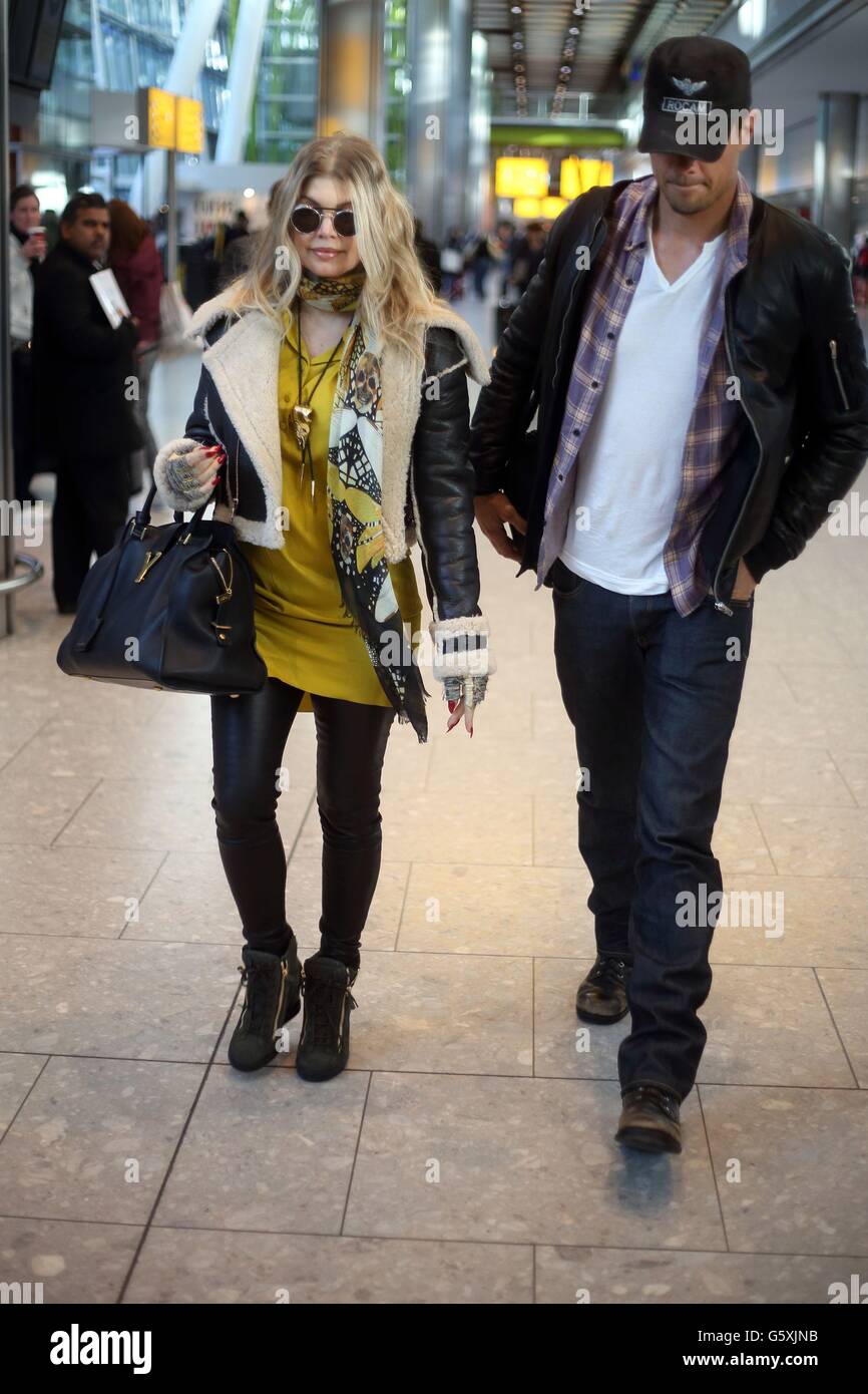 Singer Fergie (Stacy Ann Ferguson), arrive avec son mari Josh Duhamel au terminal 5 de l'aéroport de Heathrow. Banque D'Images