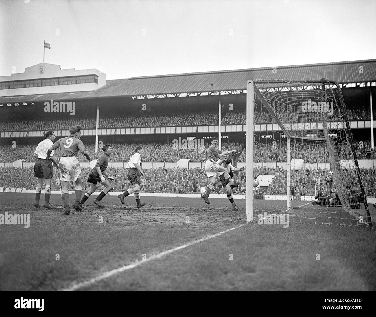 Alf Ramsey (à l'extrême droite), de Tottenham Hotspur, a perdu ce duel avec un avant John Parker d'Everton, qui a vu le visiteur marquer son premier but lors du premier match de Divison à White Hart Lane à Londres. Le gardien de but de Tottenham Hotspur Ron Reynolds (3e à partir de la gauche) s'est joint aux coéquipiers de la moitié centrale Harry Clarke (l) et de la moitié droite Bill Nicholson (4e à partir de la gauche) et au centre Everton de Dave Hickson (2e à partir de la gauche) pour observer le moment tendu. Banque D'Images