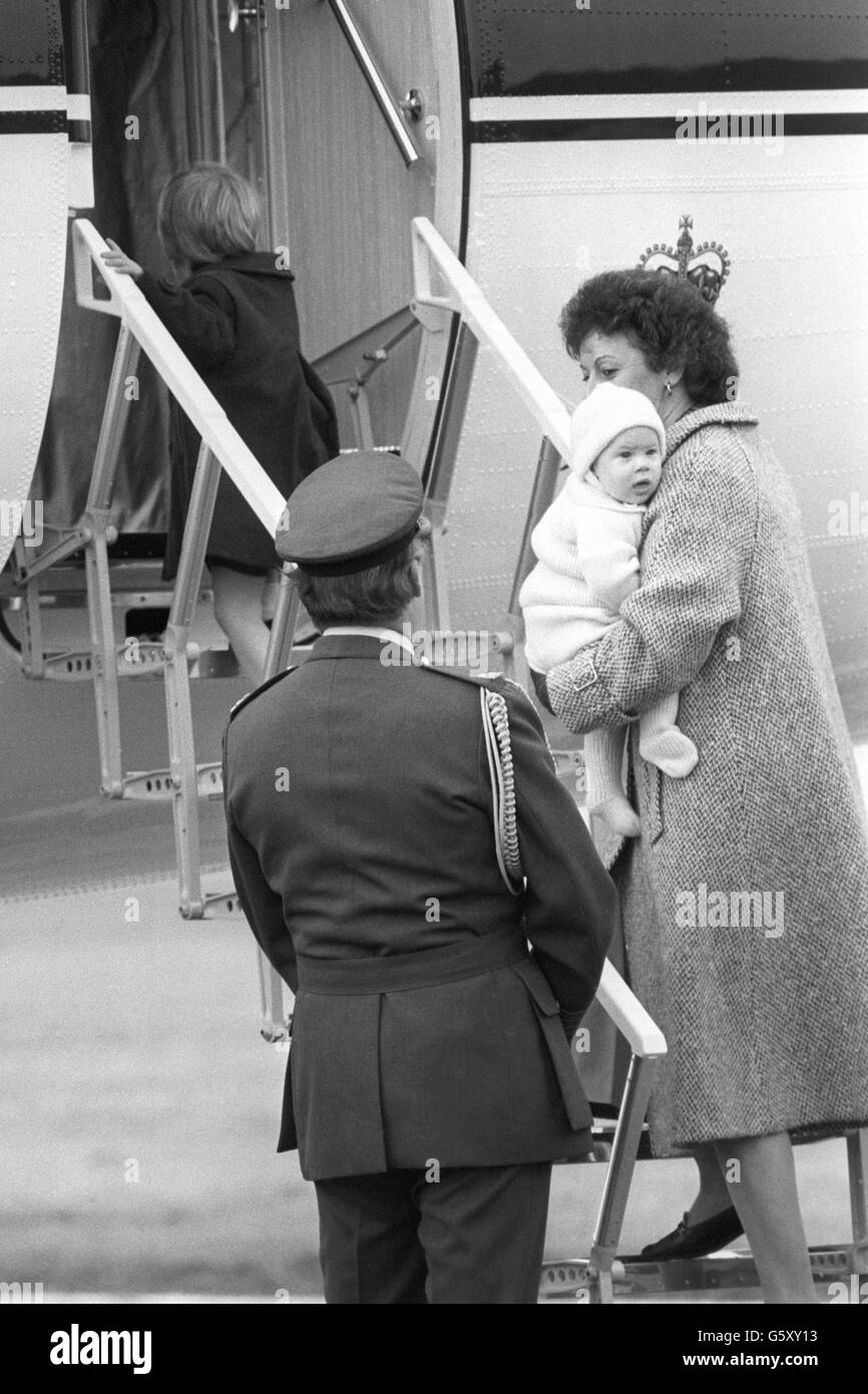 Le Prince William, qui aura trois ans en juin, marche à bord de l'avion tandis que son frère de six mois, le Prince Harry, est transporté à bord par la nounou Barbara Barnes à l'aéroport Dyce d'Aberdeen.Les enfants revolaient à Londres avec leur mère, la princesse de Galles, dans un avion du Queen's Flight. Banque D'Images