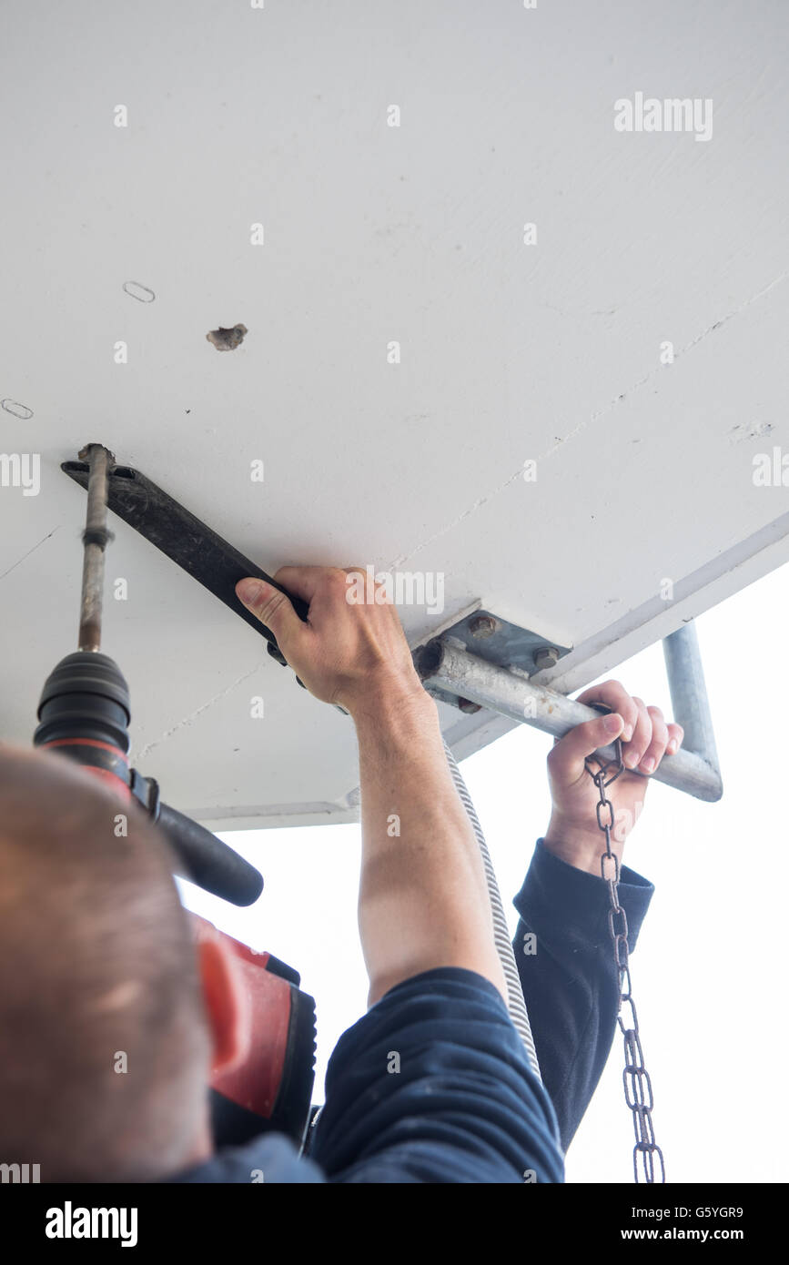 L'homme est de percer les trous dans le plafond en béton avec la machine de forage Banque D'Images