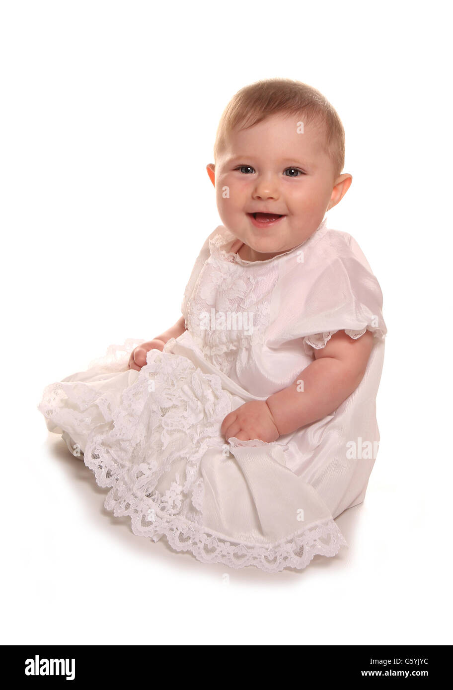 Une petite fille en robe de baptême dentelle Banque D'Images