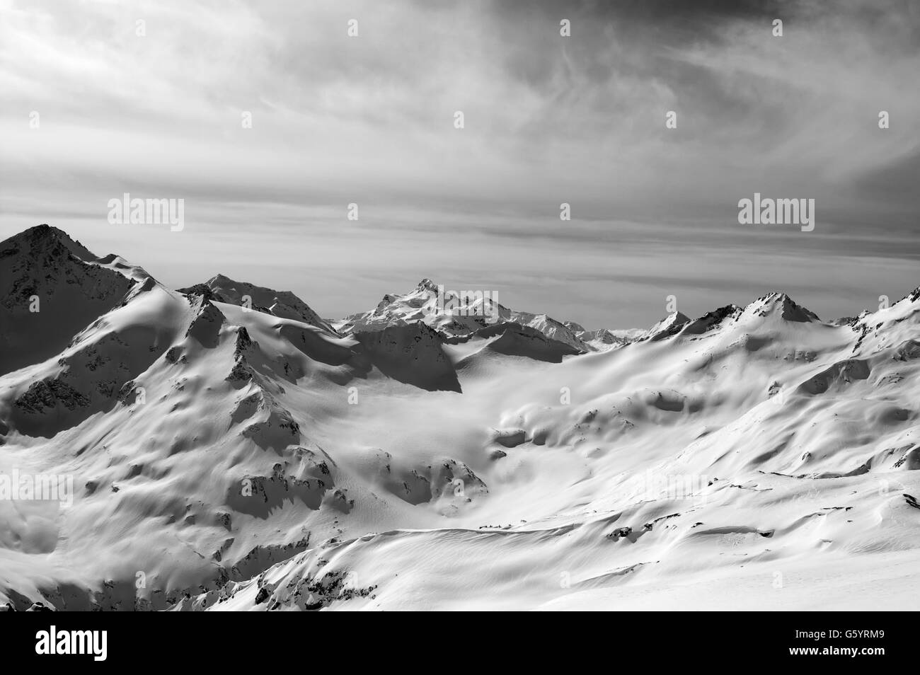 Le noir et blanc des montagnes enneigées en soirée. Montagnes du Caucase. Vue du Mt. L'elbrous. Banque D'Images Le noir et blanc des montagnes enneigées en soirée. Montagnes du Caucase. Vue du Mt. L'elbrous. Banque D'Images