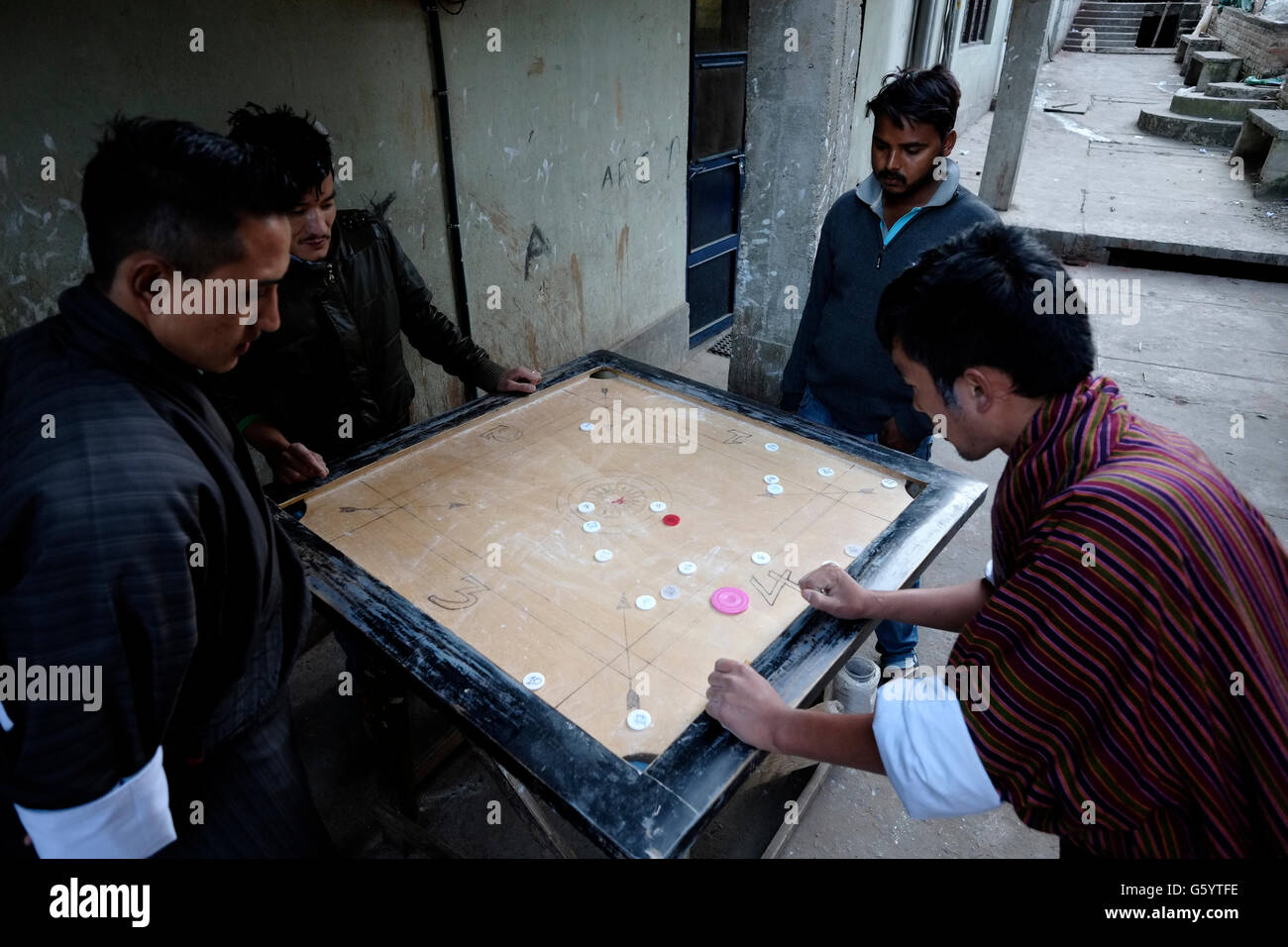 Les hommes locaux jouant le jeu de société traditionnel carrom dans le rue de Thimphu au Bhoutan Banque D'Images