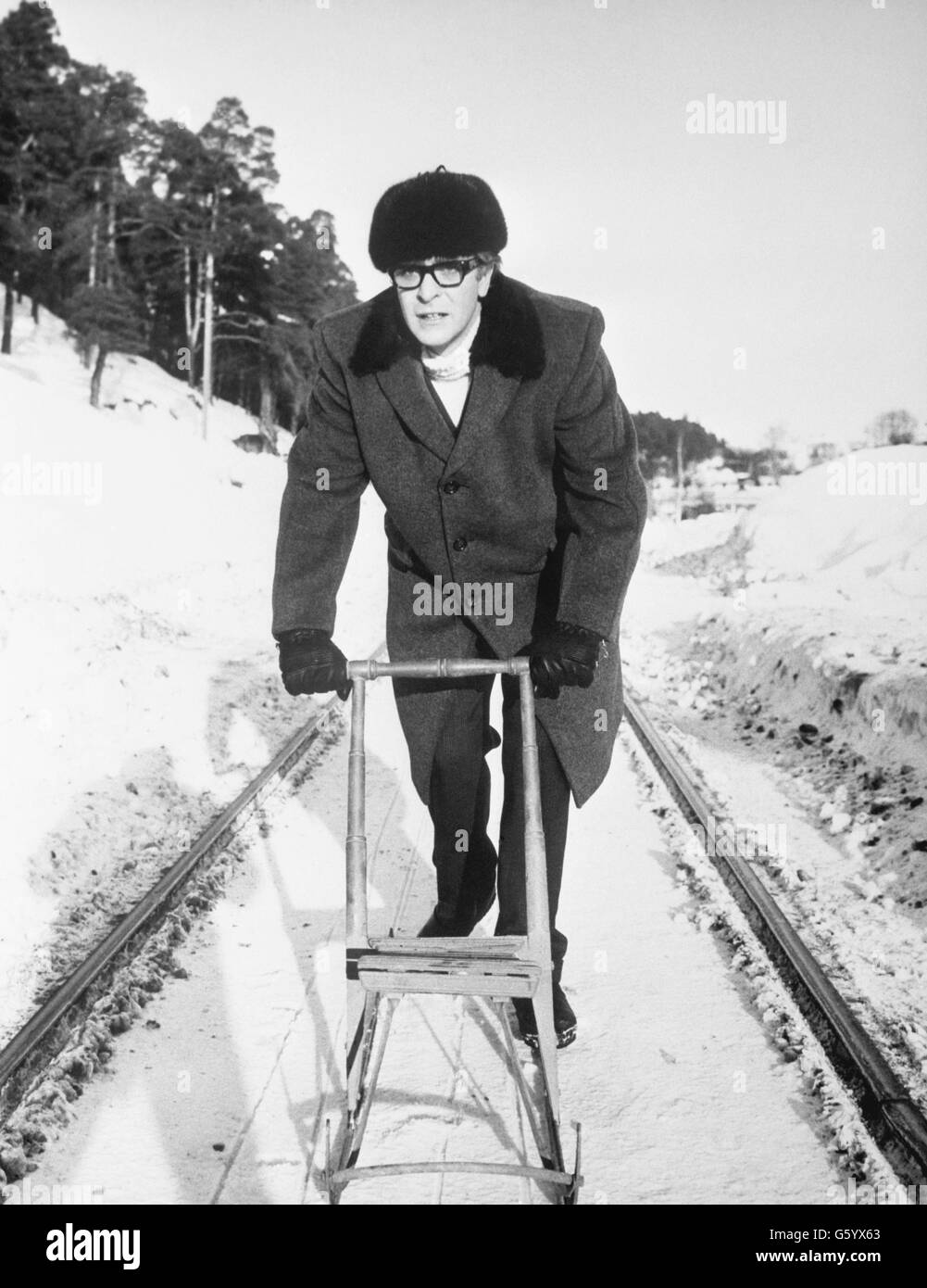 L'acteur britannique Michael Caine pousse un traîneau à coups de pied sur place en Finlande lors du tournage de son dernier film « billion Dollar Brain ».Il reprend le rôle de Harry Palmer, un agent secret de Cockney, qu'il a également joué dans 'The Ipcress File' et 'Funeral in Berlin'. Banque D'Images