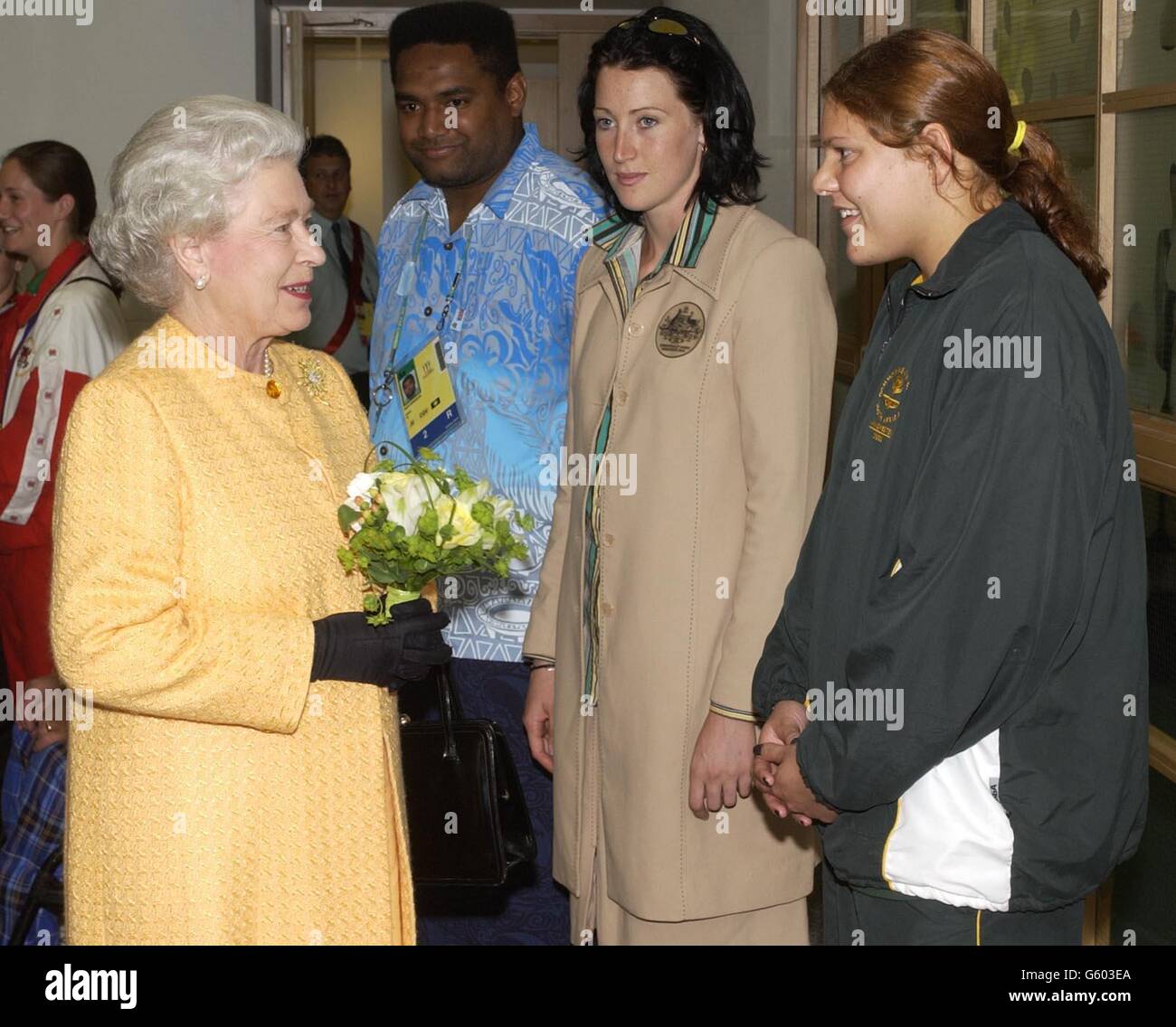 La reine Elizabeth II de Grande-Bretagne rencontre des médaillés des Jeux du Commonwealth (l-r) Nalamili Qerewaqa de Fidji, Jana Pittman d'Australie et Natalie du Tait, nageuse sud-africaine, avant la cérémonie de clôture des Jeux du Commonwealth de 2002 au stade de la ville de Manchester, à Manchester. Banque D'Images