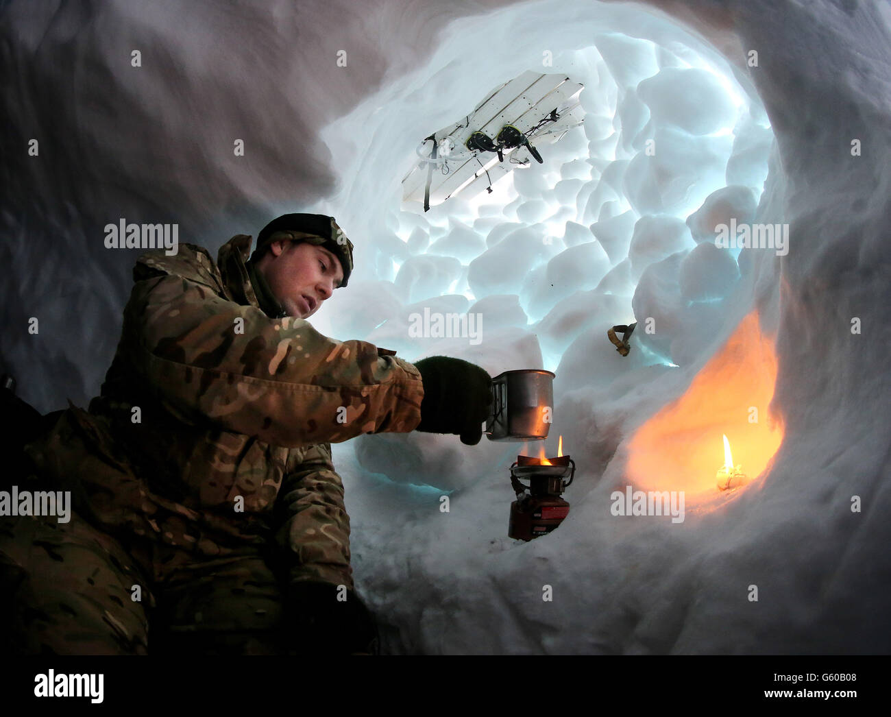 Marine Alistair McGoldrick de Chorley bout l'eau de la neige dans son trou de neige qu'ils ont construit et campé, comme les troupes prennent part à l'exercice 2013,Qui met l'accent sur la survie par temps froid et l'entraînement de guerre pour les réservistes de Royal Marines Commando dans la chaîne de montagnes près de Porsanger Garrison près de Lakselv, en Norvège. Banque D'Images