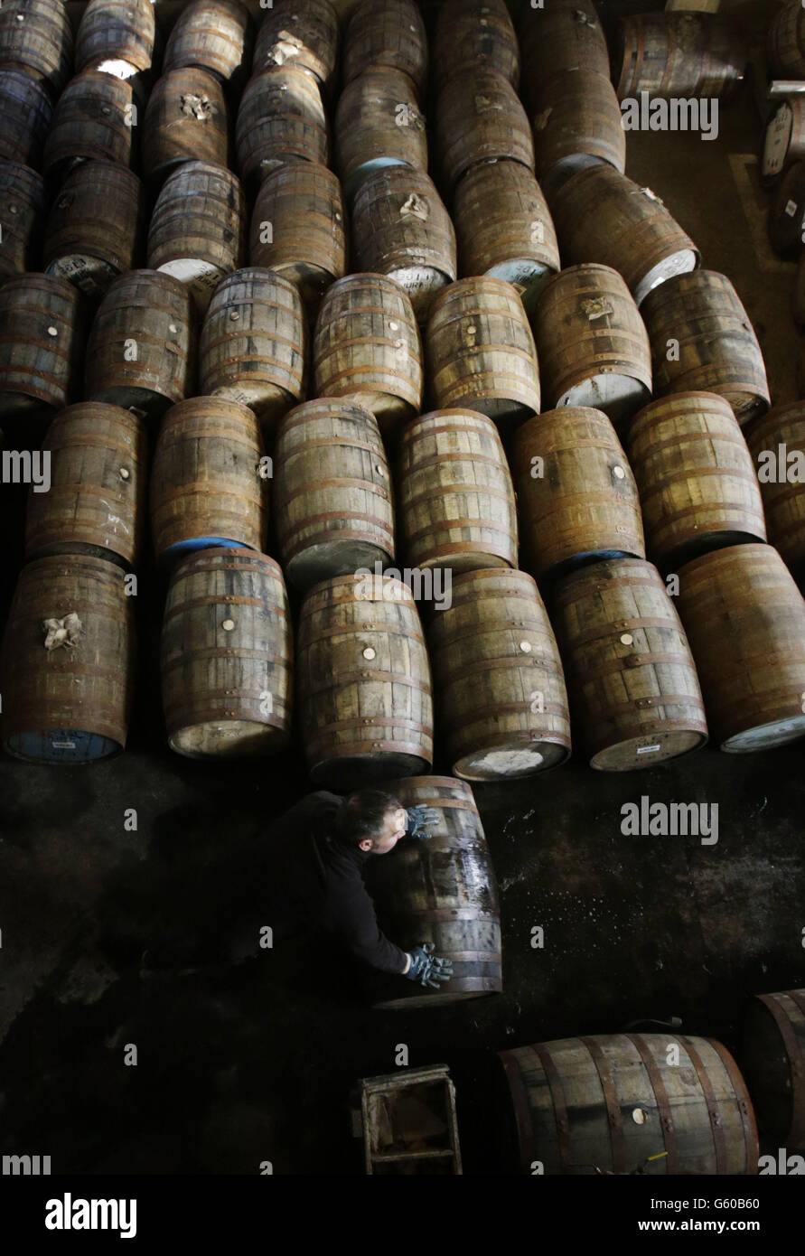 L'agent d'entreposage Graham Rozga déplace un baril de whisky à la distillerie de whisky du Jura sur l'île écossaise du Jura. Des maîtres mixeurs du monde entier se rencontreront en Écosse le mois prochain à la recherche du meilleur whisky de l'année. Banque D'Images