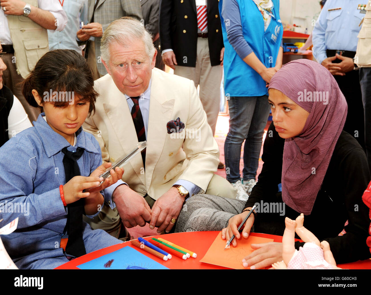 Le prince de Galles est assis avec de jeunes enfants syriens dans la pépinière du camp de réfugiés du roi Abdallah dans le nord de la Jordanie, près de la frontière syrienne, et qui abrite un peu moins d'un millier de personnes issues de la Syrie déchirée par la guerre civile. Banque D'Images