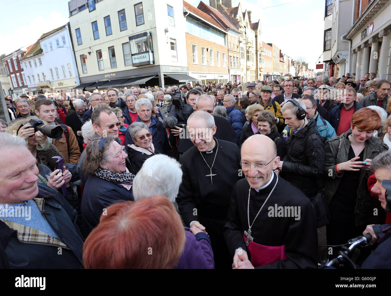 L'Archevêque de Canterbury le Révérend Justin Welby (au centre) salue les gens locaux lorsqu'il arrive à la Croix du marché, Chichester, le dernier jour de son pèlerinage dans la prière, avant son entronement en tant qu'Archevêque de Canterbury jeudi. Banque D'Images