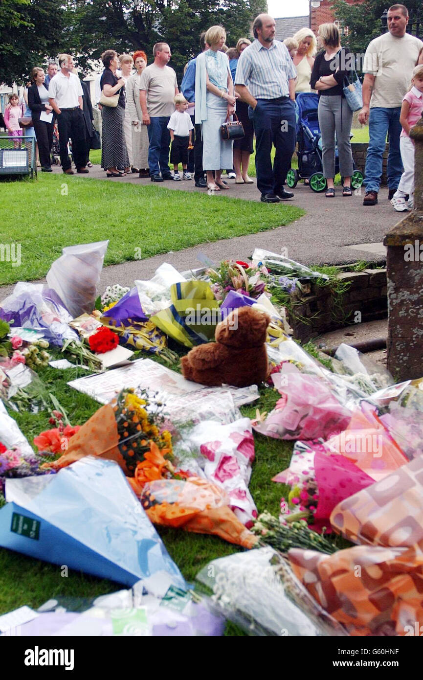 Une file d'attente de congrégation forme des fleurs passées qui ont été posées à l'extérieur de l'église St Andrew's Church, Soham, Cambridgeshire pendant le service de l'église des filles disparues, Holly Wells et Jessica Chapman. * l'église locale dans le village d'origine de Holly et Jessica a été remplie à capacité aujourd'hui pour un service spécial pour les écolières, redouté mort après la découverte de deux corps. Banque D'Images