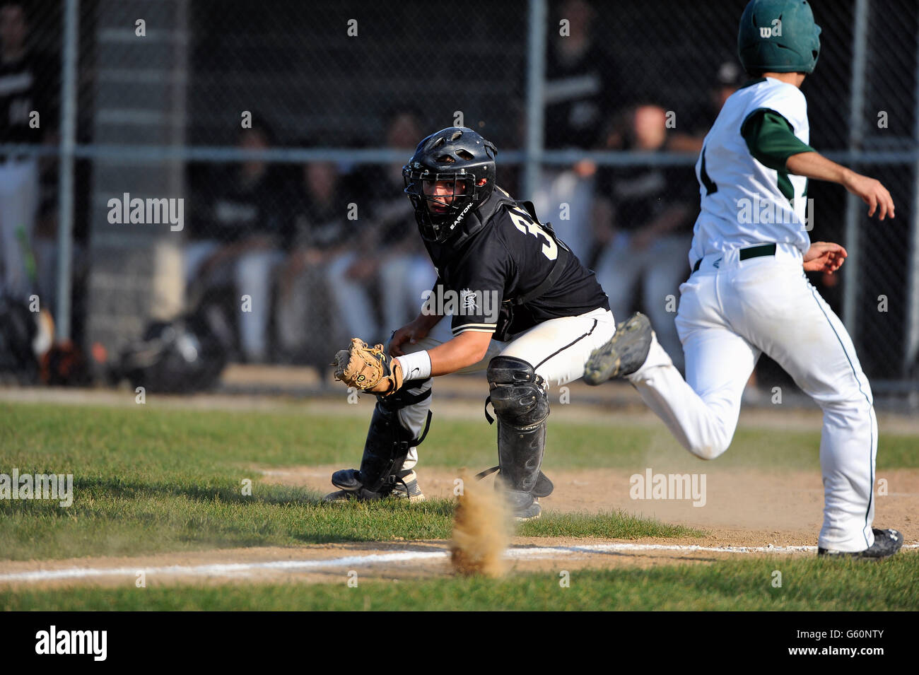 Notation Runner debout comme il bat le throw accueil à la catcher lors d'un match de l'école secondaire. USA. Banque D'Images