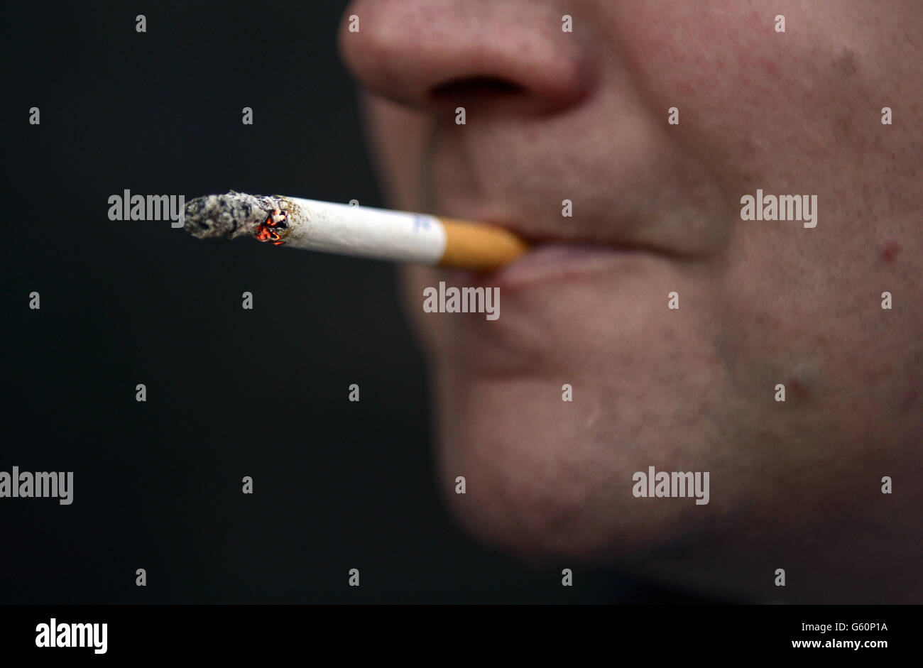 IMAGE POSÉE MON MODÈLE: Une vue générale d'un homme fume une cigarette. Banque D'Images