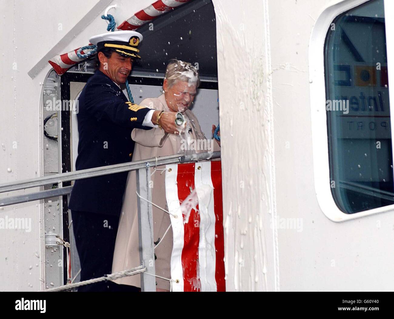 L'actrice primée Dame Judi Dench et le capitaine Claudio Cupisci sont couverts de champagne lors d'une cérémonie au port international de Harwich, dans l'Essex, pour nommer officiellement un nouveau paquebot de croisière.* c'était la troisième et réussie de Dame Judi tentative de casser une bouteille contre le navire pendant la cérémonie pour nommer le super paquebot US375M. Banque D'Images
