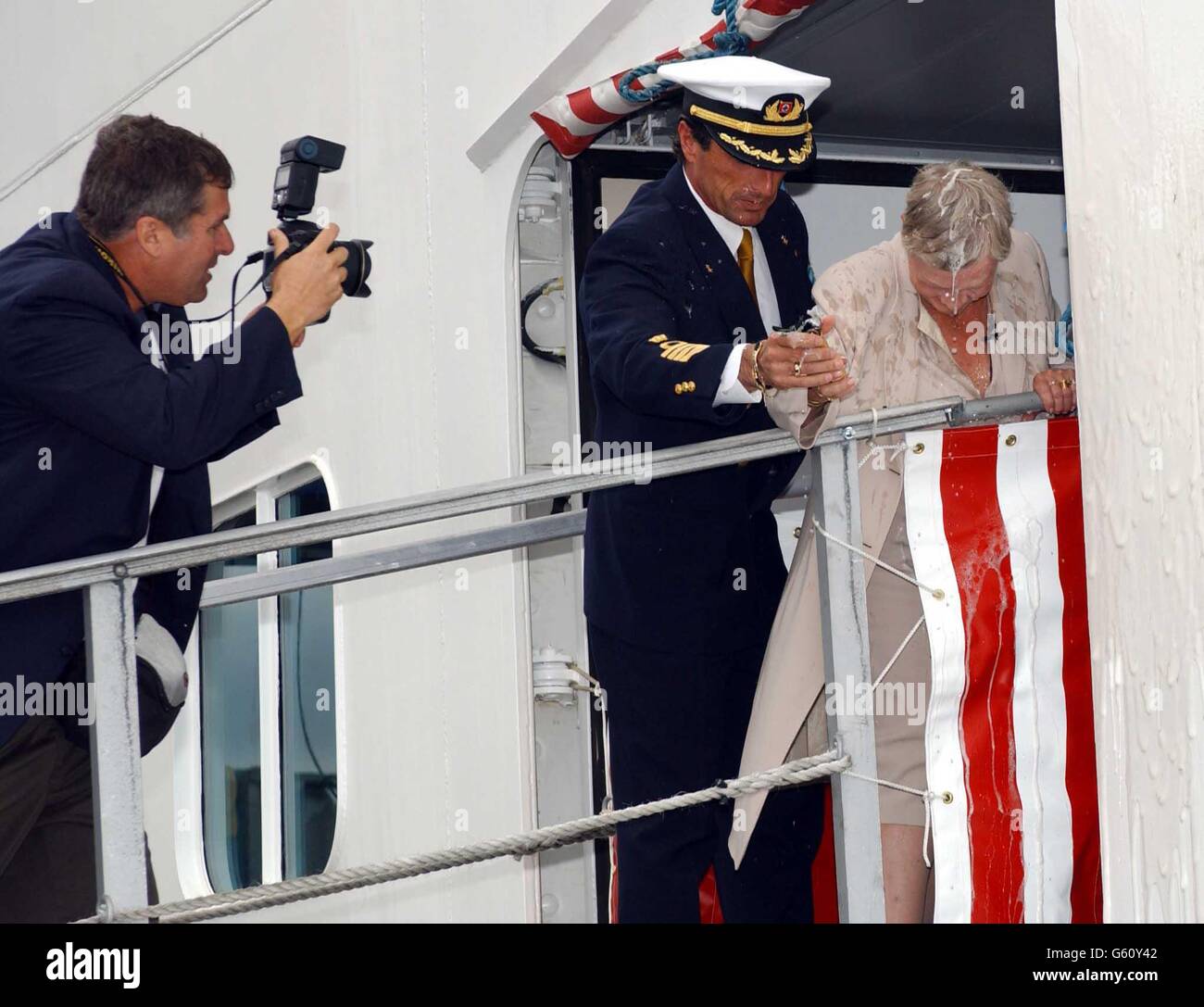 L'actrice primée Dame Judi Dench et le capitaine Claudio Cupisci sont couverts de champagne lors d'une cérémonie au port international de Harwich, dans l'Essex, pour nommer officiellement un nouveau paquebot de croisière.* c'était la troisième et réussie de Dame Judi tentative de casser une bouteille contre le navire pendant la cérémonie pour nommer le super paquebot US375M. Banque D'Images