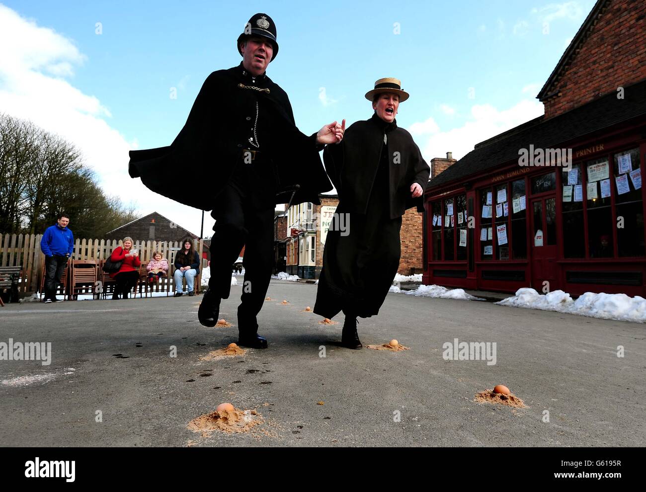 Le gendarme Jarrett et le professeur d'école Miss Burke apprécient la danse traditionnelle des œufs pendant le Vendredi Saint, à Blistes Hill, Victoria Town, Ironbridge, Shropshire. Banque D'Images