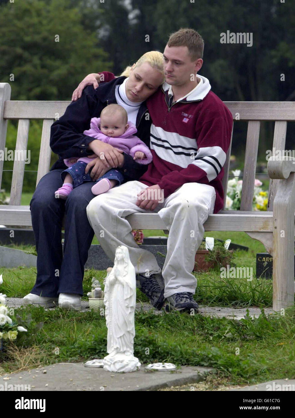 Melissa Luckett avec sa fille Katie-Jane et son associé Jason long,  s'assoient sur un banc après avoir réparé la tombe endommagée de la fille  Chloe-Jane à la section des bébés du crématorium