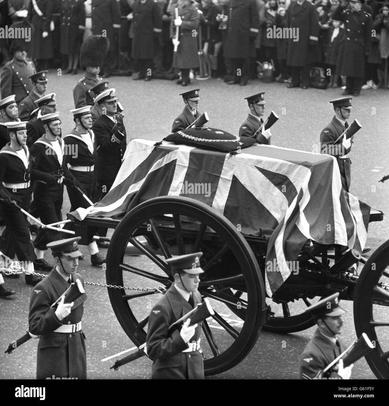 Le cercueil drapé par le drapeau de Sir Winston Churchill surmonté par l'insigne de l'ordre du Garter sur la porte-armes à travers le Strand dans le cortège funéraire de l'État. Banque D'Images