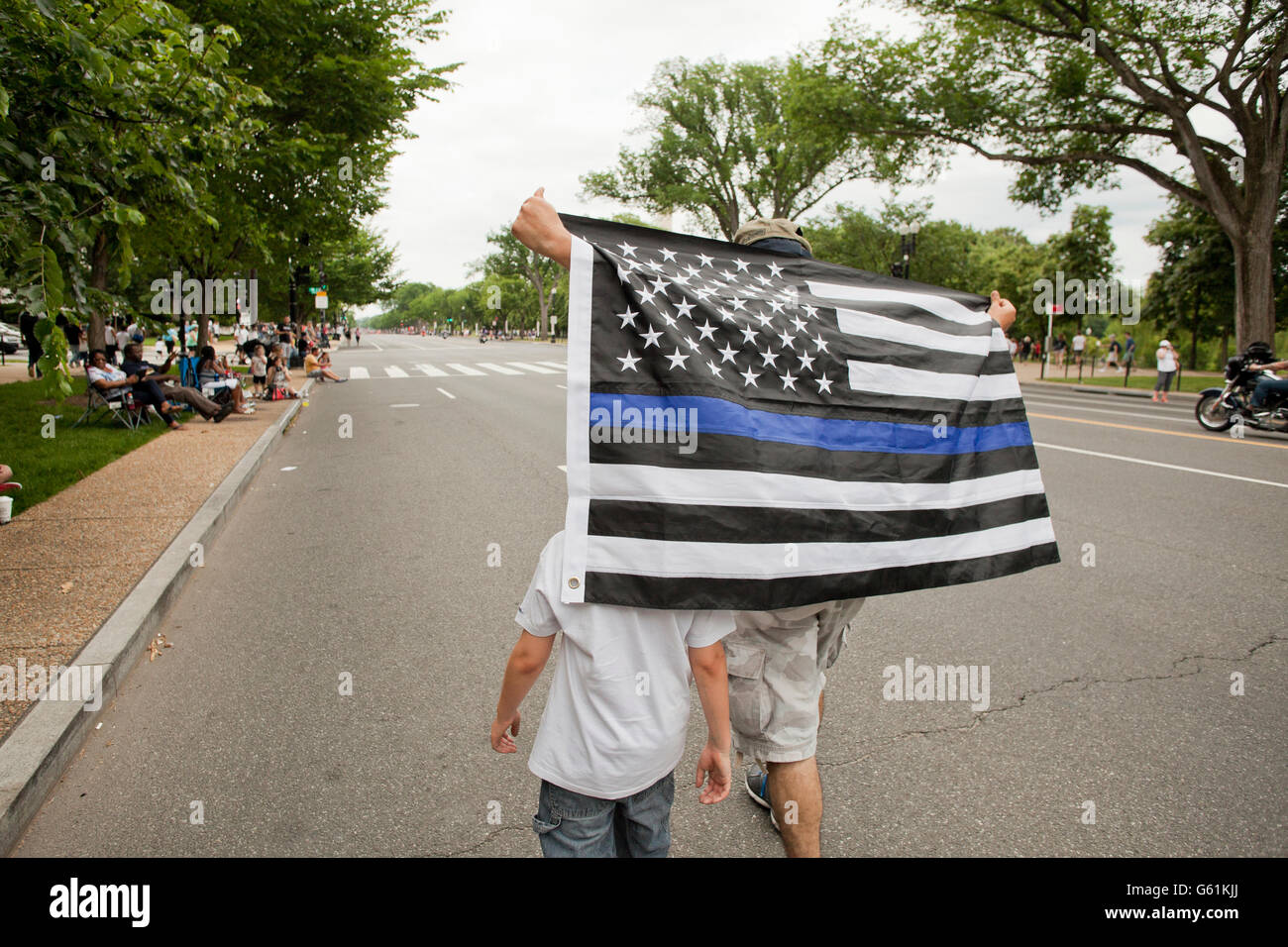 L'homme et l'enfant tenant un drapeau bleu (Blue Line vit peu importe) - USA Banque D'Images