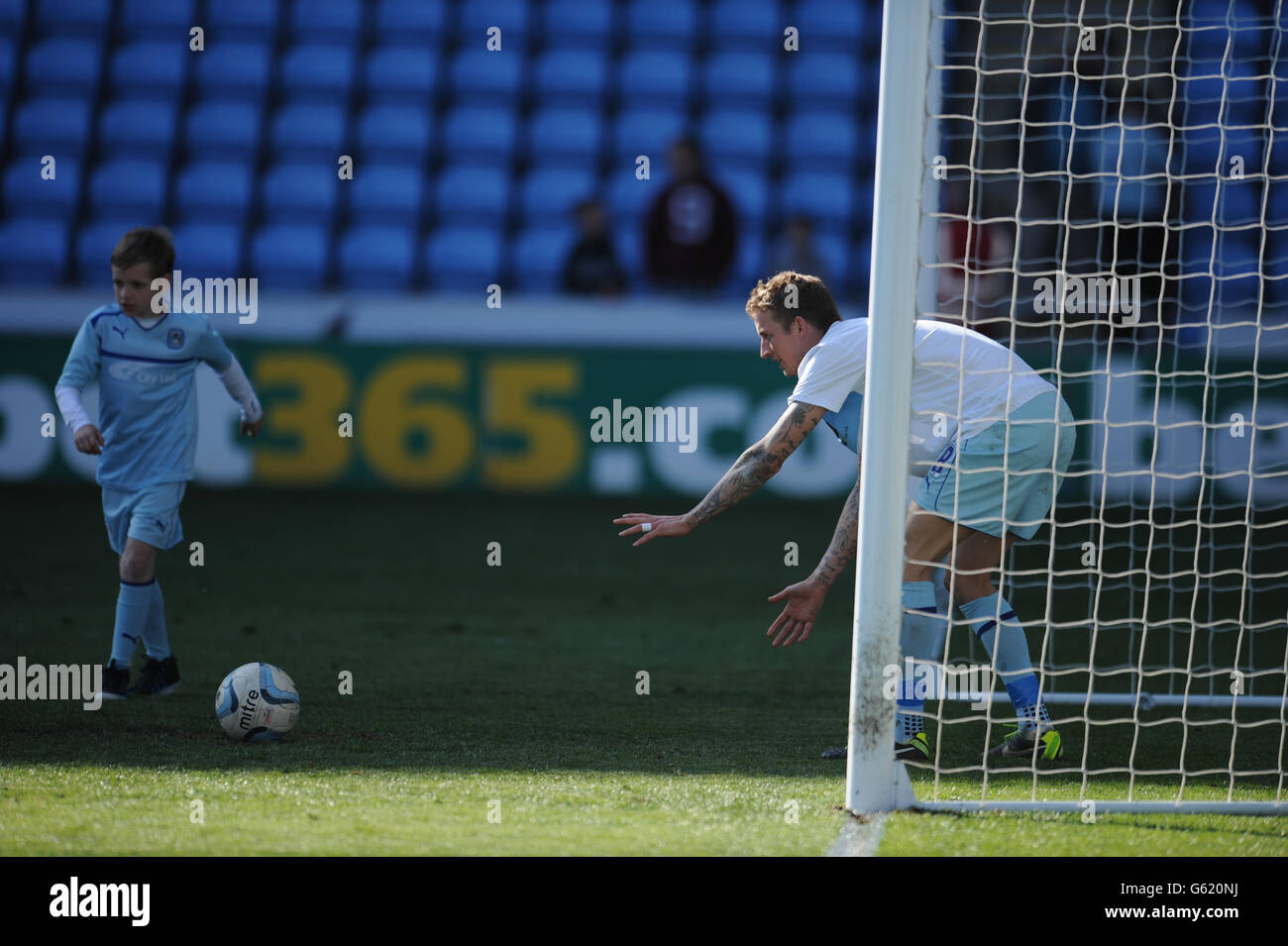 Coventry City Carl Baker sur le terrain avec les mascottes Banque D'Images