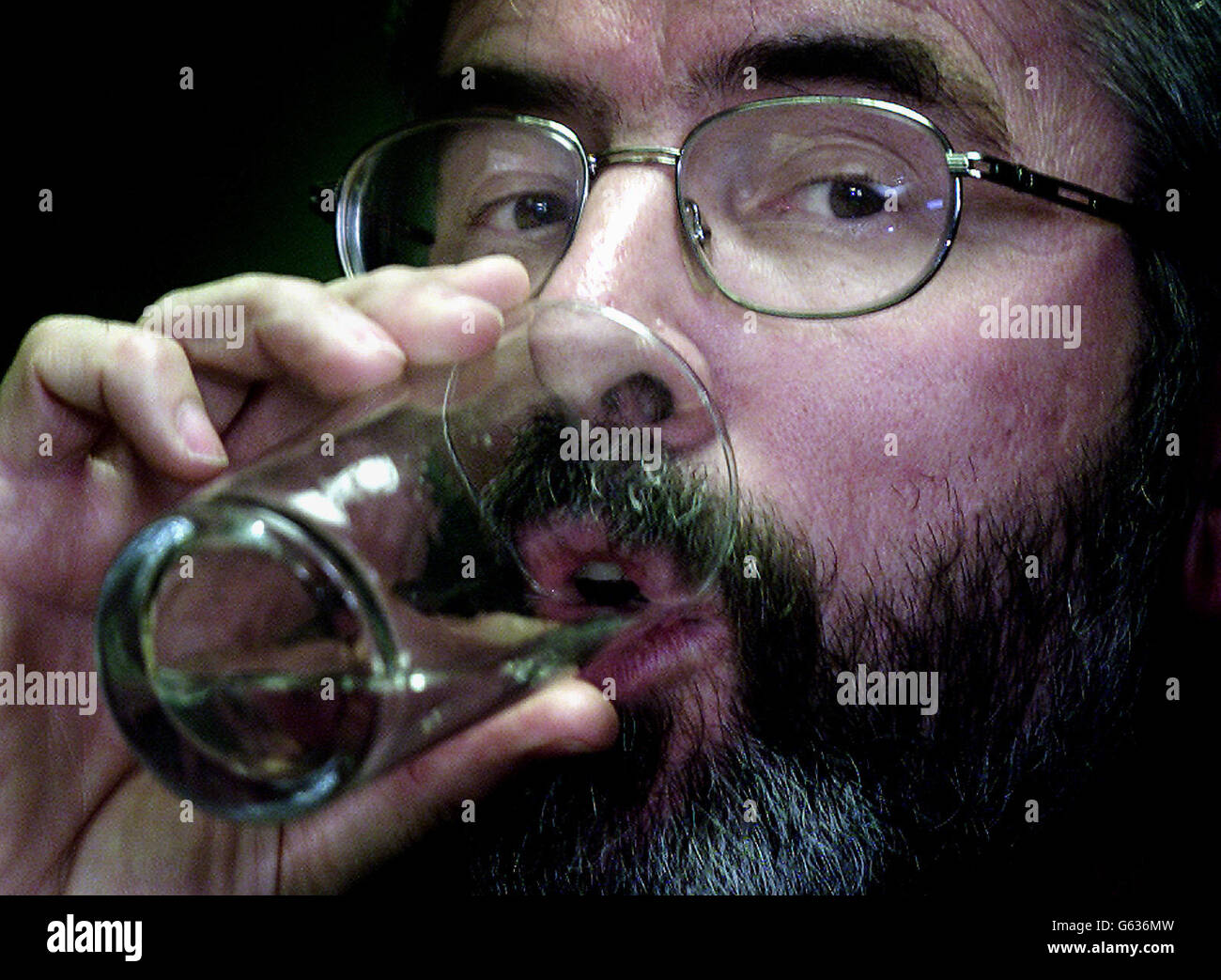 Le président de Sinn Fein, Gerry Adams, prend un verre d'eau dans son bureau sur la route des chutes à Belfast. Demain, il rencontrera le Premier ministre britannique Tony Blair à Downing Street à Londres pour entendre le sort de son parti. * M. Adams a déclaré qu'il n'y avait aucun motif d'expulser son parti de l'exécutif de partage du pouvoir en Irlande du Nord et a ajouté que le gouvernement irlandais doit continuer son opposition à toute suspension des institutions. Banque D'Images