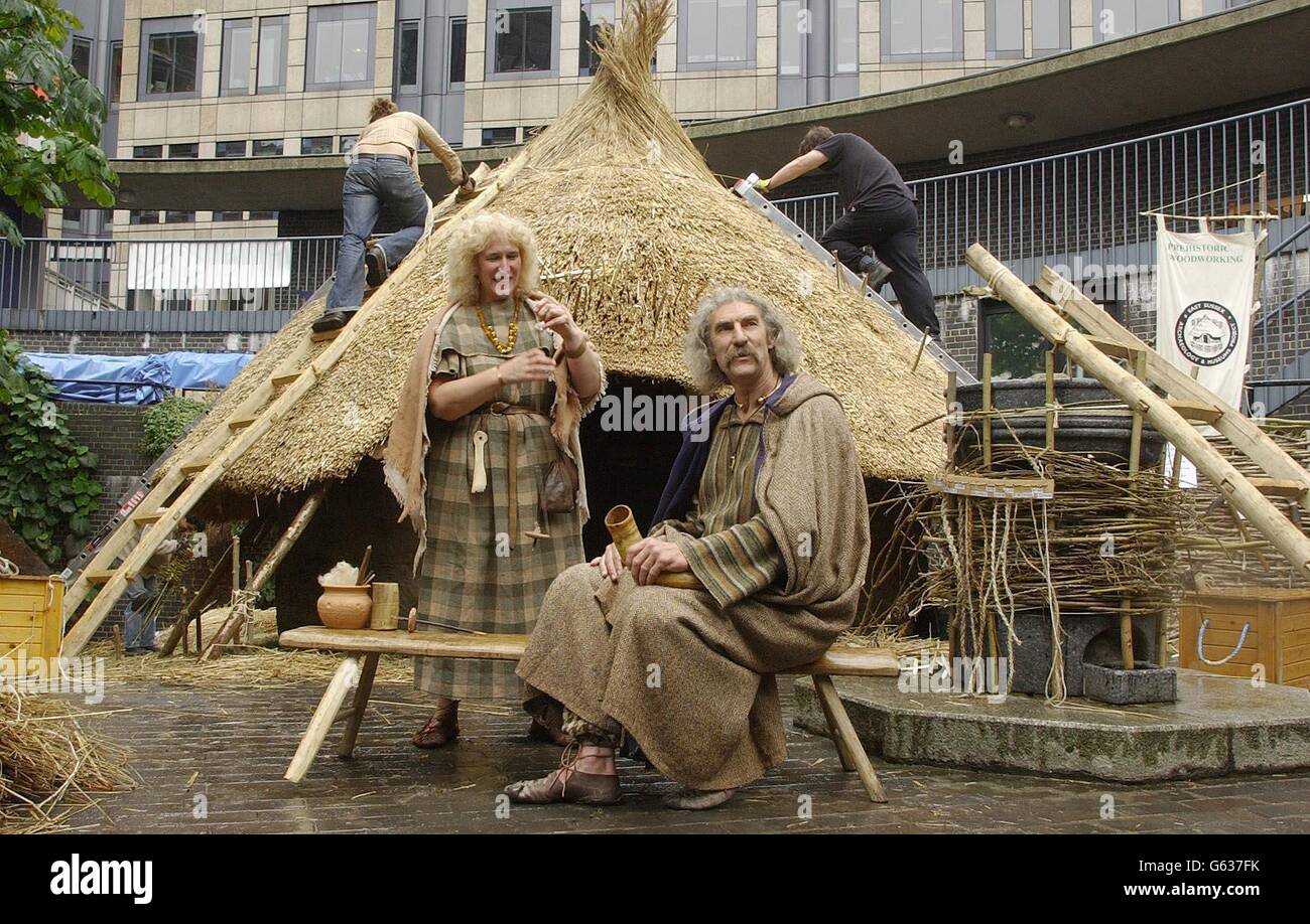 Veratrix connu sous le nom de David Freeman, âgé de 52 ans, de Bournemouth à Dorset, avec sa femme Ann devant son roundhouse préhistorique qui était encore en cours de construction à l'extérieur du Musée de Londres. * la maison de 4.2 mètres qui est construite avec 350 tiges de havel, 260 liasses de roseau et une tonne d'argile, sera la maison de M. Freeman pour la semaine prochaine pour coïncider avec l'ouverture de la nouvelle galerie préhistorique du Musuem, Londres avant Londres. Banque D'Images