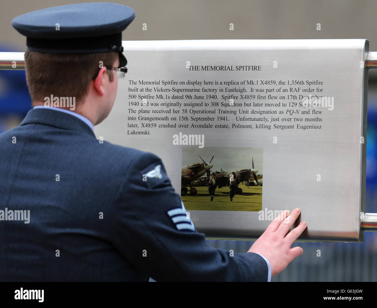 Un tableau d'information est lu au cours d'une cérémonie pour dévoiler une réplique de Spitfire comme un mémorial à 71 pilotes stagiaires qui ont perdu la vie pendant la Seconde Guerre mondiale.La grande Supermarine Spitfire Mark 1 a été dévoilée par l'ancien mécanicien d'avions Dinger Bell, âgé de 100 ans, à Grangemouth, près du site d'un ancien aérodrome.L'idée du monument commémoratif de Spitfire est venue des cadets du corps d'entraînement aérien de l'escadron 1333 (Grangemouth Spitfire).Il a coûté 100,000 livres sterling, qui ont été recueillis par le biais de campagnes menées par le Grangemouth Spitfire Memorial Trust. Banque D'Images