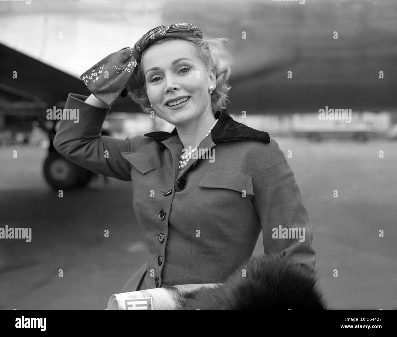 Le ZSA ZSA Gabor d'Hollywood s'attache à son nouveau turban à l'aéroport de Londres à son arrivée de Paris par Air France. Banque D'Images