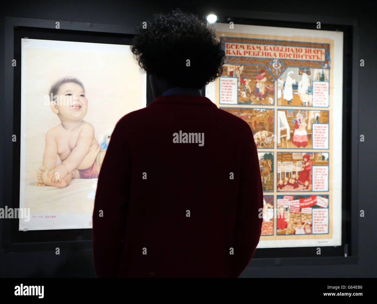 Un homme voit des affiches qui sont exposées dans le cadre de l'exposition propagande: Pouvoir et persuasion à la British Library dans le centre de Londres. Banque D'Images