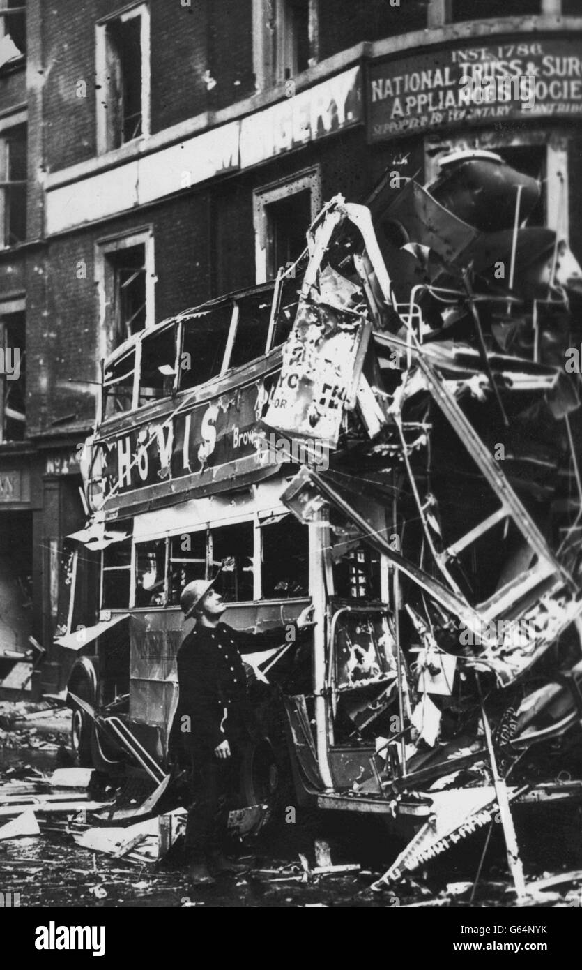 Londres: Une scène dans la ville après un raid aérien allemand.Un pompier regarde les restes tordus d'un bus à impériale. Banque D'Images