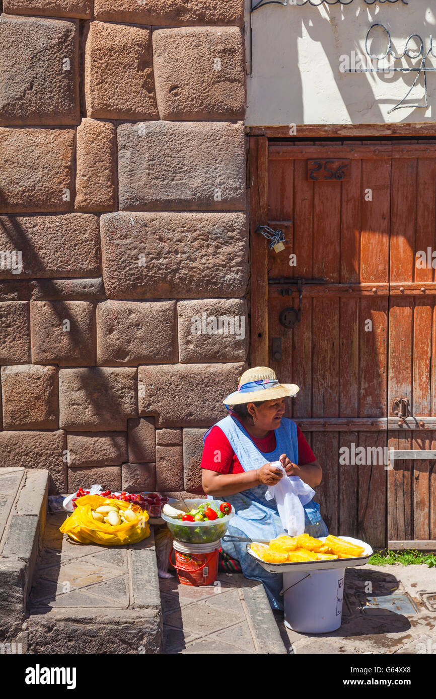 Femme vendant de l'Ananas, salade, pommes de terre et sur un trottoir de Cusco Banque D'Images