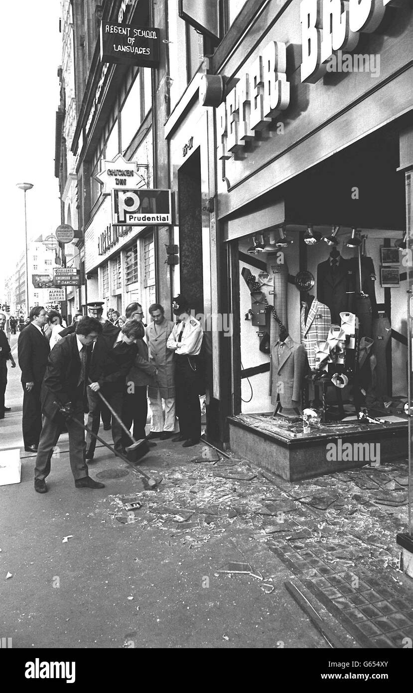 Les employés aident à nettoyer le désordre de verre brisé devant Peter Brown, un putfitter d'Oxford Street, après qu'une bombe a explosé au pied de certains bureaux à côté. Banque D'Images