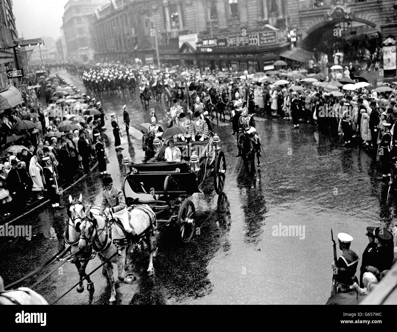 Les parapluies sont en haut comme les Londoniens saluent le président William Shadrach Tubman du Libéria quand il conduit avec toi Reine, également à l'abri sous un parapluie, de la gare de Victoria au palais de Buckingham. Banque D'Images