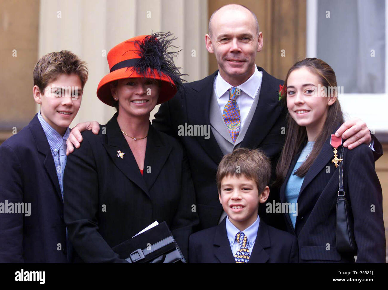 Clive Woodward, responsable de l'Union de rugby d'Angleterre (centre) avec sa famille après avoir reçu son OBE de la Reine, à l'extérieur du Palais de Buckingham. * ils sont (de gauche à droite): Joe, 14, femme Jayne, Freddie, 8, Et Jess, 16. Sous Woodward, l'Angleterre a atteint le haut du classement mondial. Banque D'Images