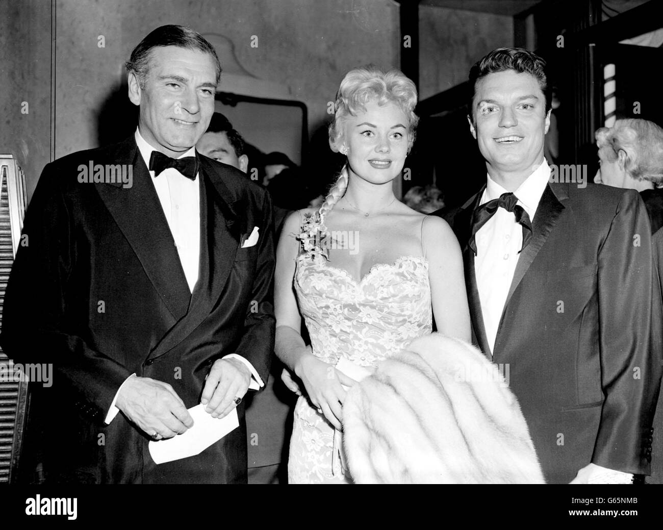 Sir Laurence Olivier arrivies avec le chanteur Guy Mitchell et son épouse pour la première royale de gala de son film "The Viking" au Leicester Square Theatre, Londres. Banque D'Images