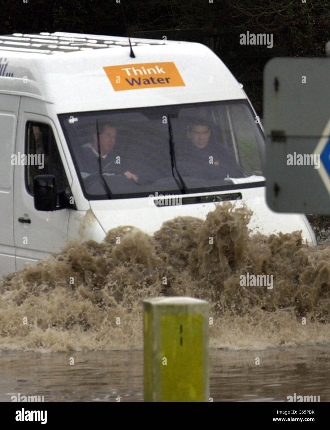 Une fourgonnette est conduite à travers une grande piscine d'eau couvrant une route glissante sur l'autoroute M50 près de Tewkesbury, car les fortes précipitations continuent de causer des problèmes à travers le pays. Banque D'Images