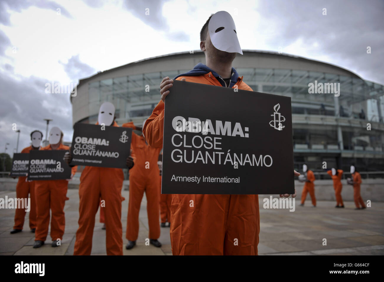 Les manifestants d'Amnesty International, vêtus de combinaisons et de masques orange, ont des pancartes demandant que le président des États-Unis, Barack Obama, ferme Guantanamo, alors qu'ils se rassemblent devant le front de mer de Belfast, avant le sommet du G8. Banque D'Images
