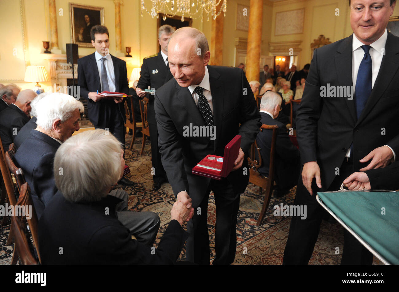 Le Premier ministre David Cameron (à droite) et le président russe Vladimir Poutine (au centre) lors d'une cérémonie pour remettre la médaille russe Ushakov aux anciens combattants de convoi de l'Arctique, au 10 Downing Street, Londres. Banque D'Images