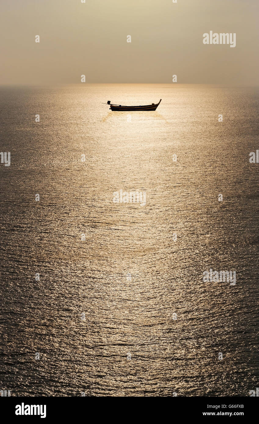 L'eau de la texture de la mer avec bateau de pêche et du soleil dans ton sombre Banque D'Images