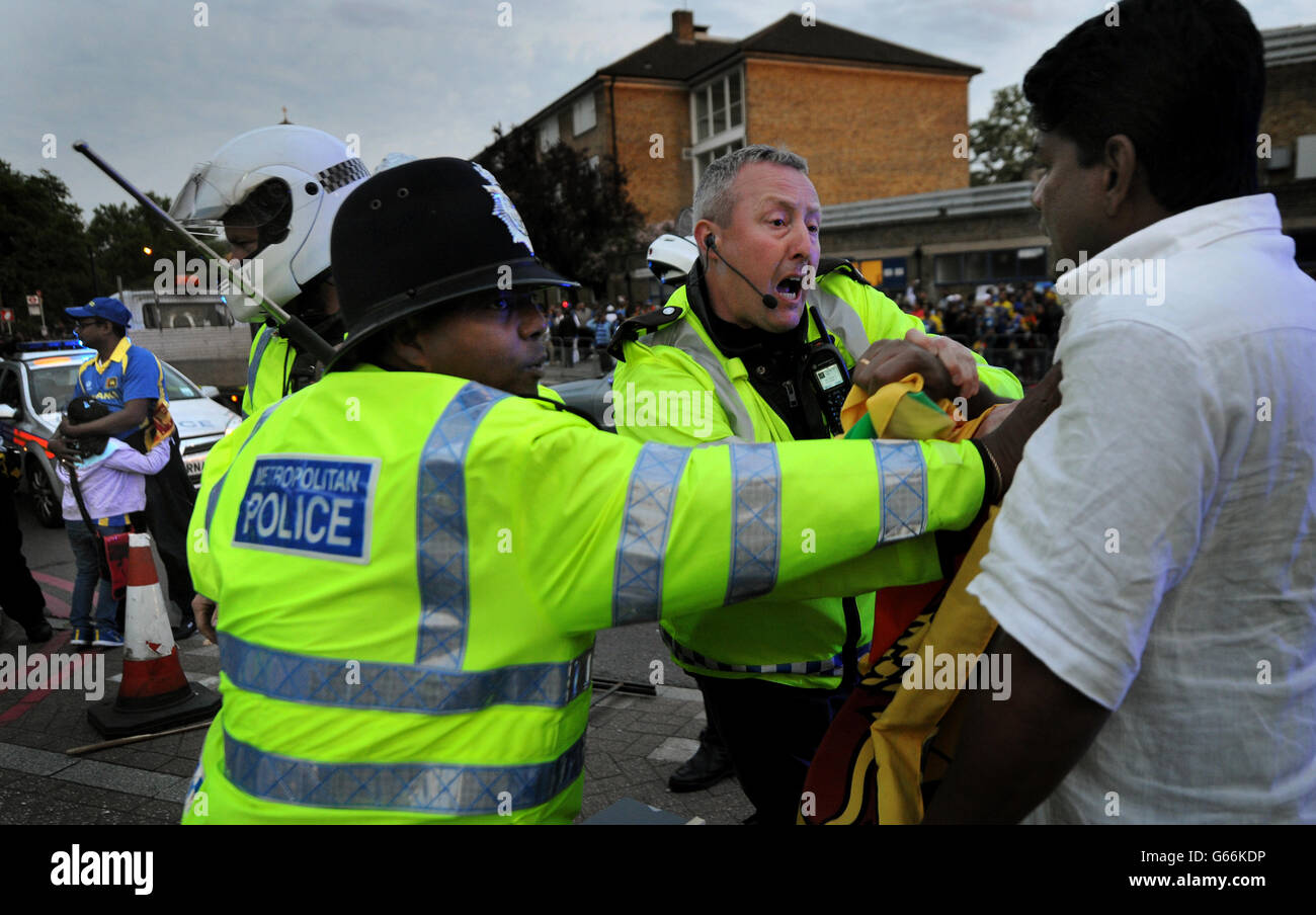 Les fans de cricket sri lankais s'affrontent avec la police et les manifestants du Sri Lanka qui a été expulsé du groupe de protestation du Commonwealth après le match du Trophée des champions de la CPI à l'Oval, à Londres. Banque D'Images