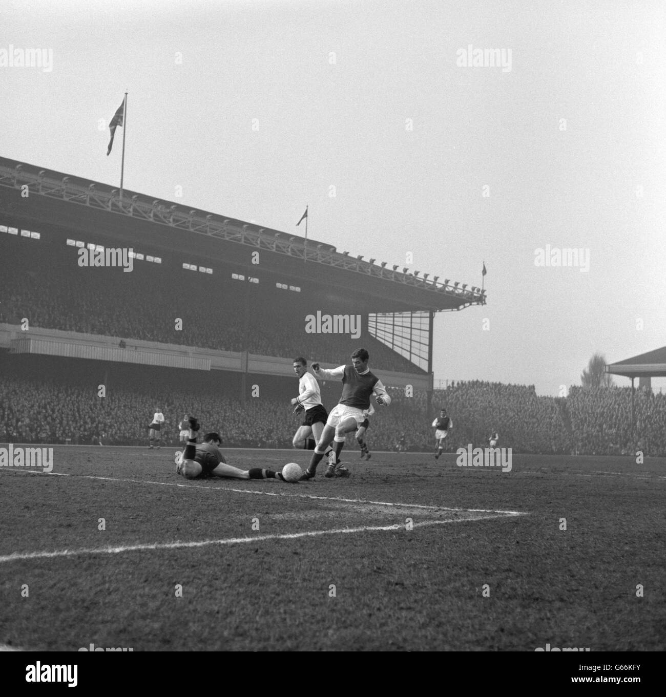 Geoffrey Strong, à l'intérieur de l'arsenal, passe devant le gardien de but de Burnley Adam Blacklaw et la moitié gauche de Brian Miller pour marquer le premier but des Gunners lors du match de la première division à Highbury, Londres. Banque D'Images