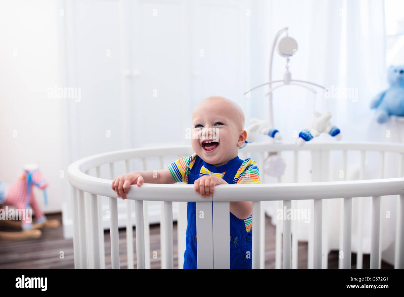 Rires De Bebe Mignon Debout Dans Un Lit Rond Blanc Pepiniere Blanc Pour Les Jeunes Enfants Petit Garcon Apprendre A Rester Dans Son Lit A Photo Stock Alamy