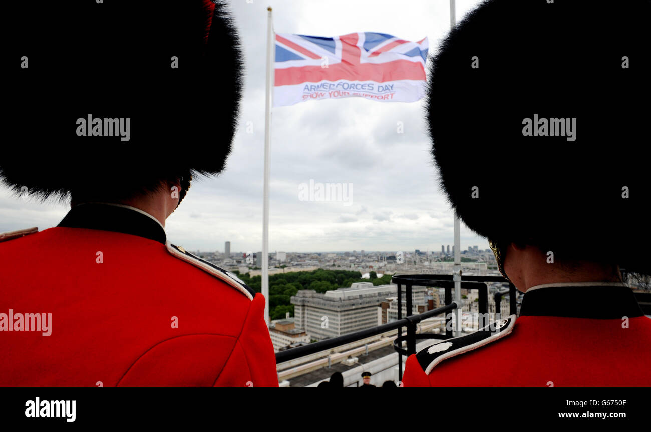 Des membres des Scots et des Coldstream Guards se tiennent sur le toit de l'hôtel de ville de Westminster, à Westminster, dans le centre de Londres, alors que le drapeau des forces armées est levé pour marquer le début de la semaine des forces armées. Banque D'Images