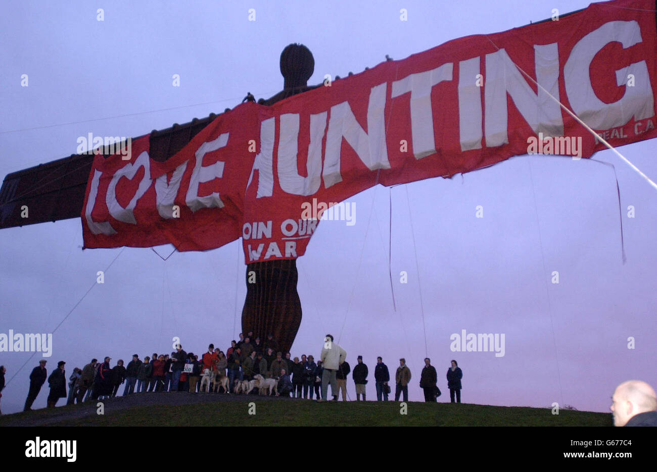 Les militants pro-chasse se tiennent sous une immense bannière accrochée à l'Ange du Nord - la plus grande sculpture de Grande-Bretagne - comme message de la Saint-Valentin à leur sport. Environ 100 membres du Real CA, partisans radicaux de la chasse pro liés à la Countryside Alliance, ont assisté à la montée de deux grégleurs près de Gateshead pour dévoiler une bannière rouge de 40 mètres de long et de 10 mètres de haut qui se lit comme « l'amour de la chasse rejoint notre guerre » en lettres de cinq mètres de haut. Banque D'Images