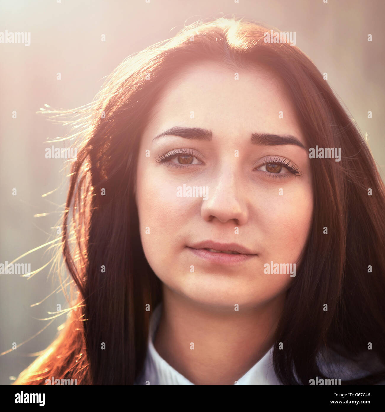 Portrait d'une jeune jolie fille dans une chemise légère et avec ses cheveux à l'extérieur Banque D'Images