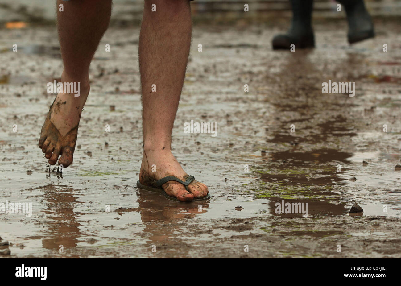 Un gardien de festival portant un seul flip-flop dans la boue au Festival de Glastonbury, à la ferme digne de Somerset.APPUYEZ SUR ASSOCIATION photo.Date de la photo: Jeudi 27 juin 2013.Le crédit photo devrait se lire: Yui Mok/PA Wire Banque D'Images